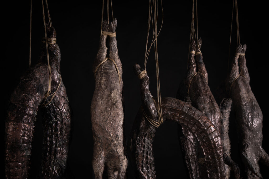 Detalle de escultura de cocodrilo colgado Archivo de cuerpos, escultura de Darío Zoel